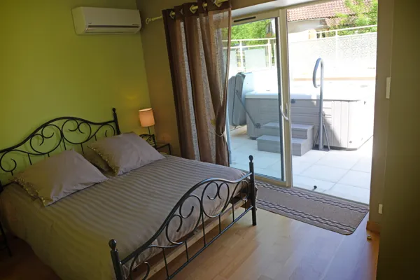 Chambre verte avec accès à la terrasse du SPA par une baie vitrée, Chambre verte