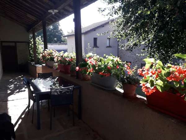 balcon fleuri avec table et 4 chaises