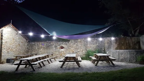 Place du village éclairée la nuit, La Grange du Heron