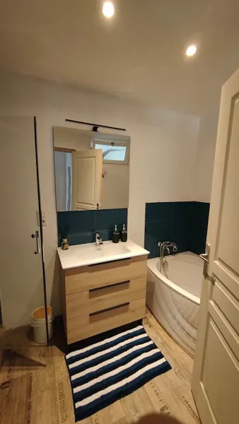 Salle de bain (Douche - Baignoire - Evier - Mirroir - Sèche-cheveux à disposition dans meuble - Gel douche et shampoing disponible)