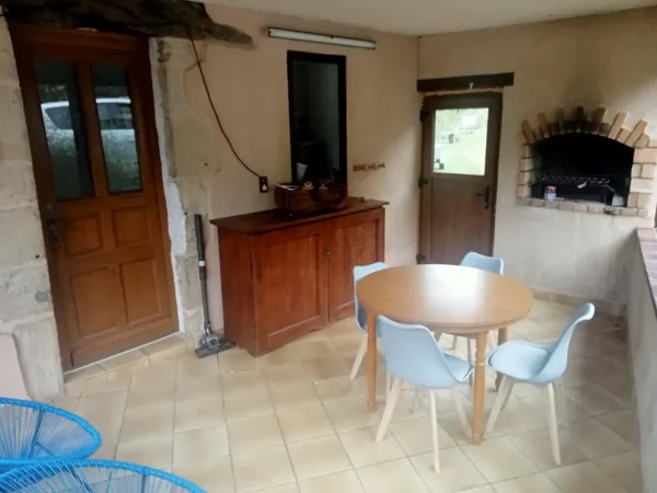 Véranda et sa cheminée où vous pourrez manger et cuire vos grillades