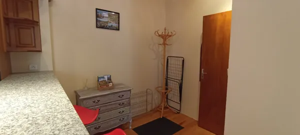 Entrée fonctionnelle avec meuble de rangement et porte-manteau, offrant un accueil pratique dès l’arrivée.