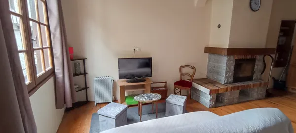 Séjour chaleureux avec cheminée et télévision, idéal pour des moments conviviaux en famille ou entre amis.