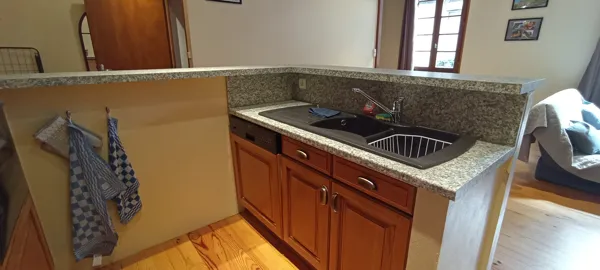 Cuisine fonctionnelle équipée d’un évier double et d’un plan de travail en granit.