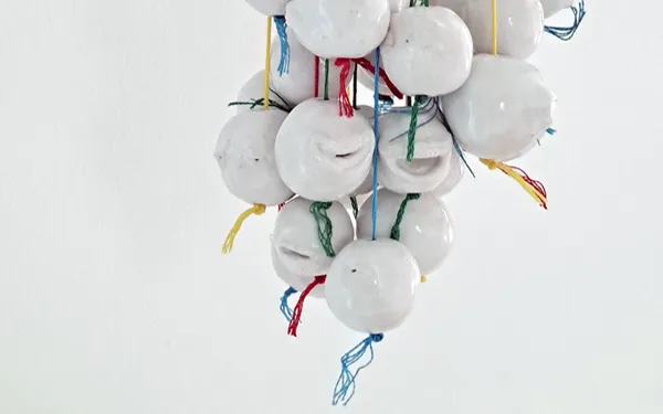 Anthea Lubat, I 'MEMBER (je souviens), 2025, suspension de perles-visages en céramique.