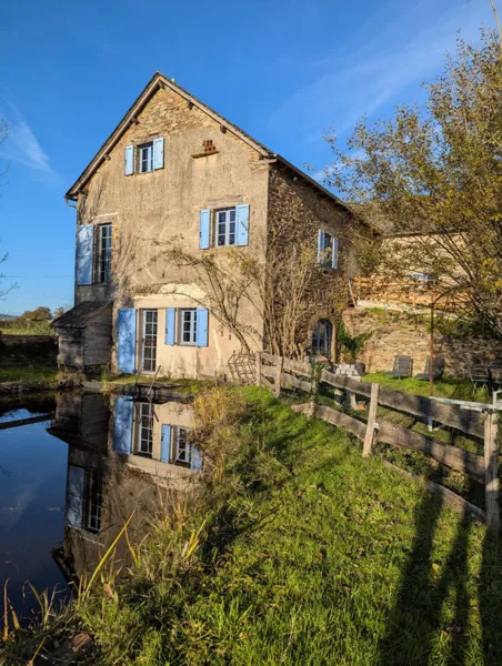 La maison d’hôtes Saisonnée se reflète dans l’ancien bassin naturel, offrant une atmosphère paisible et authentique au cœur du Ségala, à Centrès., Maison d’hôtes Saisonnée