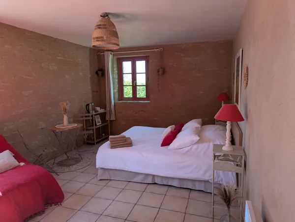 La chambre Champêtre, avec ses murs en pierre et son ambiance douce, offre un cocon chaleureux pour un séjour ressourçant à Saisonnée, en Aveyron., Maison d’hôtes Saisonnée