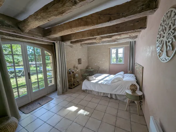 La chambre Verdoyante, lumineuse et ouverte sur le jardin, offre une ambiance naturelle et apaisante pour un séjour en Aveyron., Maison d’hôtes Saisonnée