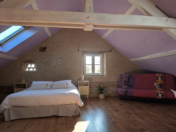 Chambre chaleureuse sous les combles avec lit double confortable et clic-clac pour couchage supplémentaire. Un espace lumineux et authentique pour un séjour paisible à Saisonnée, au cœur de l’Aveyron., Maison d’hôtes Saisonnée