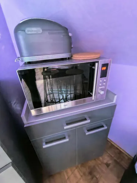 Espace cuisine du gîte Panoramique avec micro-ondes, rangements et équipements pratiques pour préparer facilement ses repas durant un séjour en Aveyron., Maison d’hôtes Saisonnée