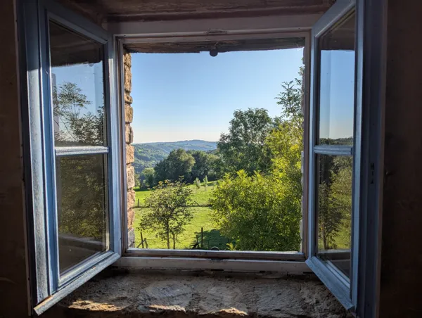 Vue imprenable sur la vallée depuis la fenêtre du gîte Panoramique. Un panorama apaisant au cœur de la campagne aveyronnaise, idéal pour un séjour ressourçant., Maison d’hôtes Saisonnée