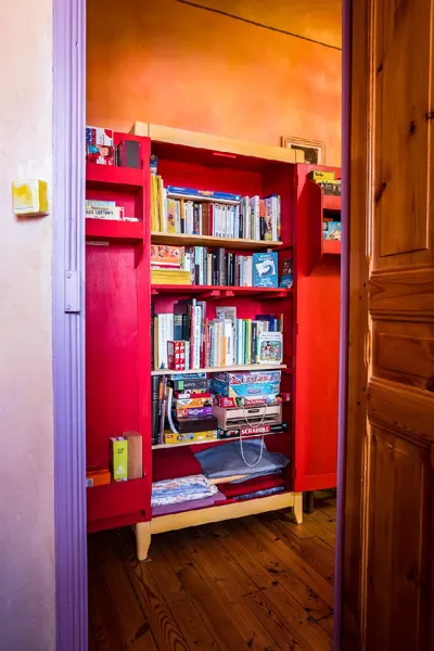 Dans le couloir des chambres : une jolie bibliothèque avec de nombreux livres et jeux