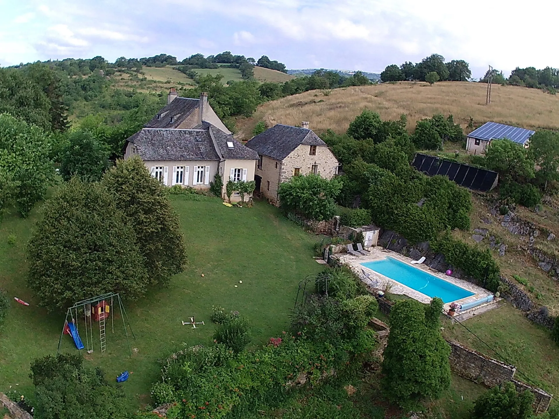 Domaine de Bellevue d'Olt, la piscine et le jardin avec la balancoire et la petite maison pour enfants, Domaine de Bellevue - Alain Prieur