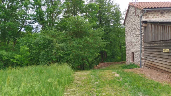 le parking du gîte et l'accès à la rivière à gauche du muret
